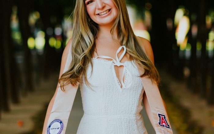 Graduation picture of Maycee holding her University of Arizona stole.