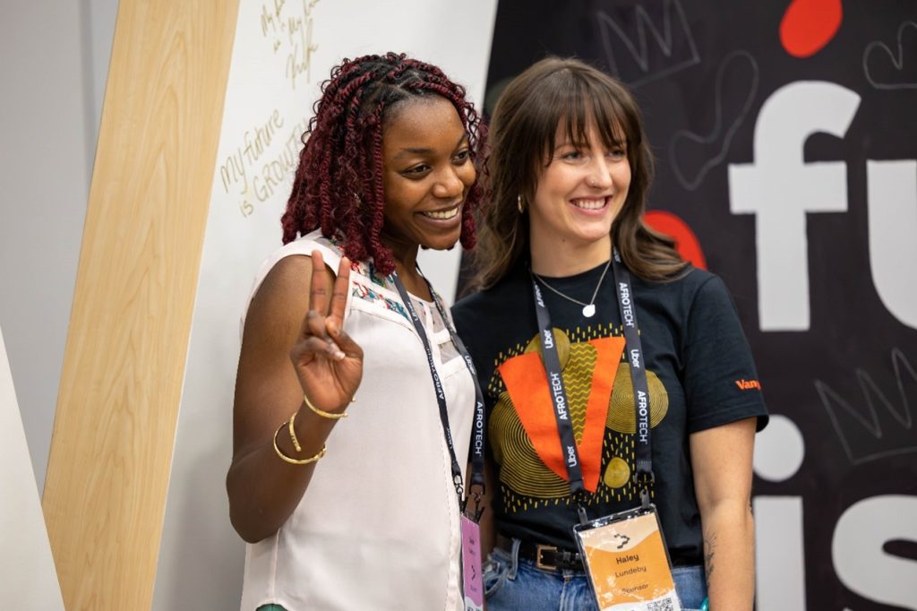 Haley L. smiling and posing with an attendee at the AfroTech conference.