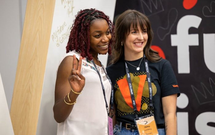Haley L. smiling and posing with an attendee at the AfroTech conference.
